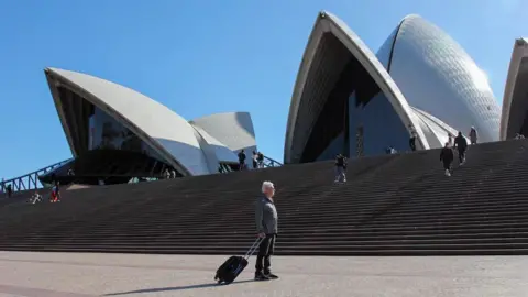 Terry Harper avec sa valise devant l’Opéra de Sydney