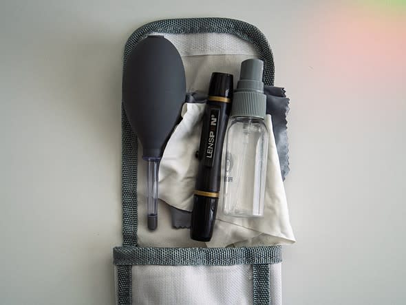 Une sélection d’outils de nettoyage pour appareil photo posés sur un bureau blanc