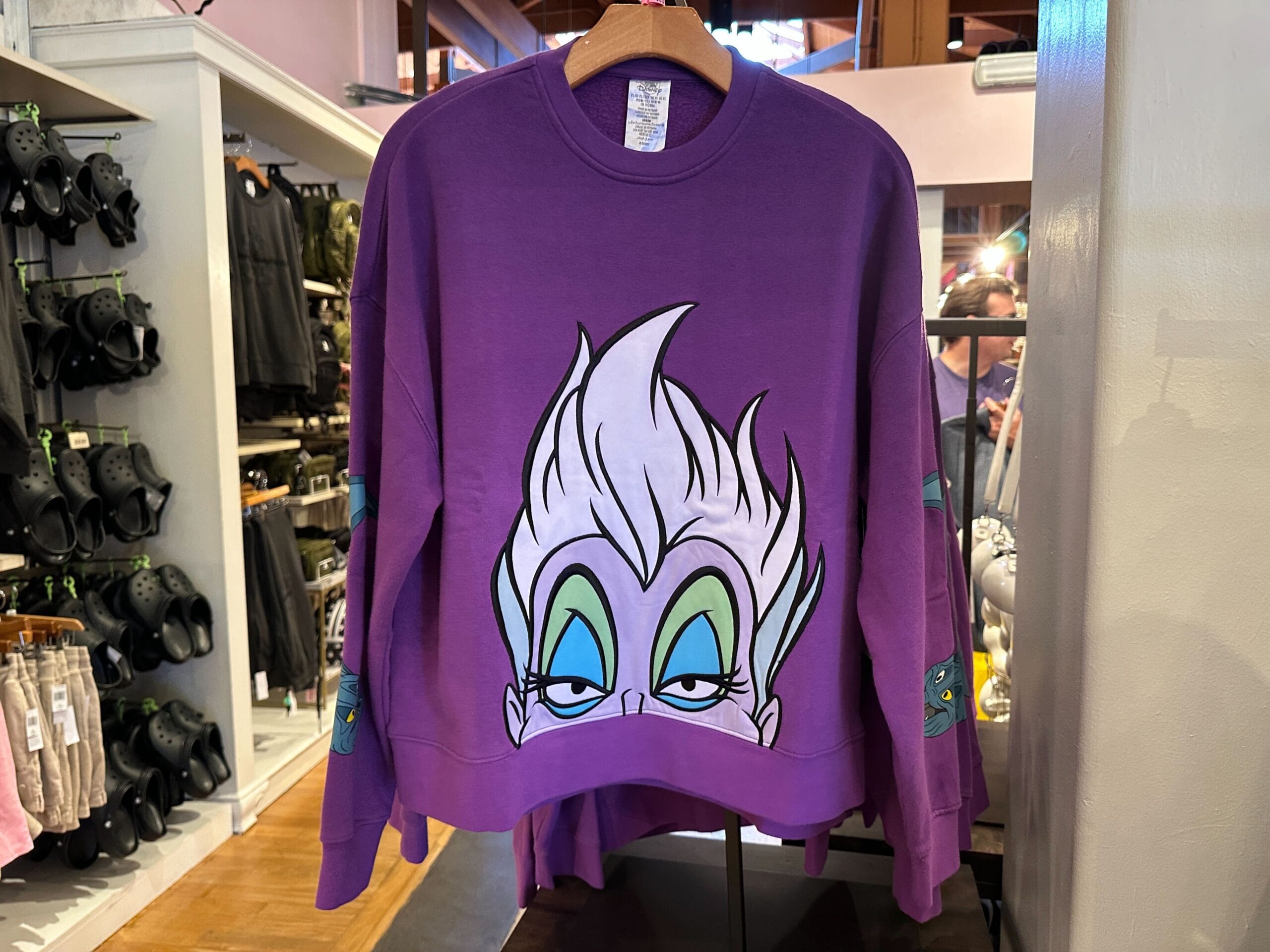 Sweatshirt violet avec visage et coiffure d’Ursula de 'La Petite Sirène' estampillés sur le devant