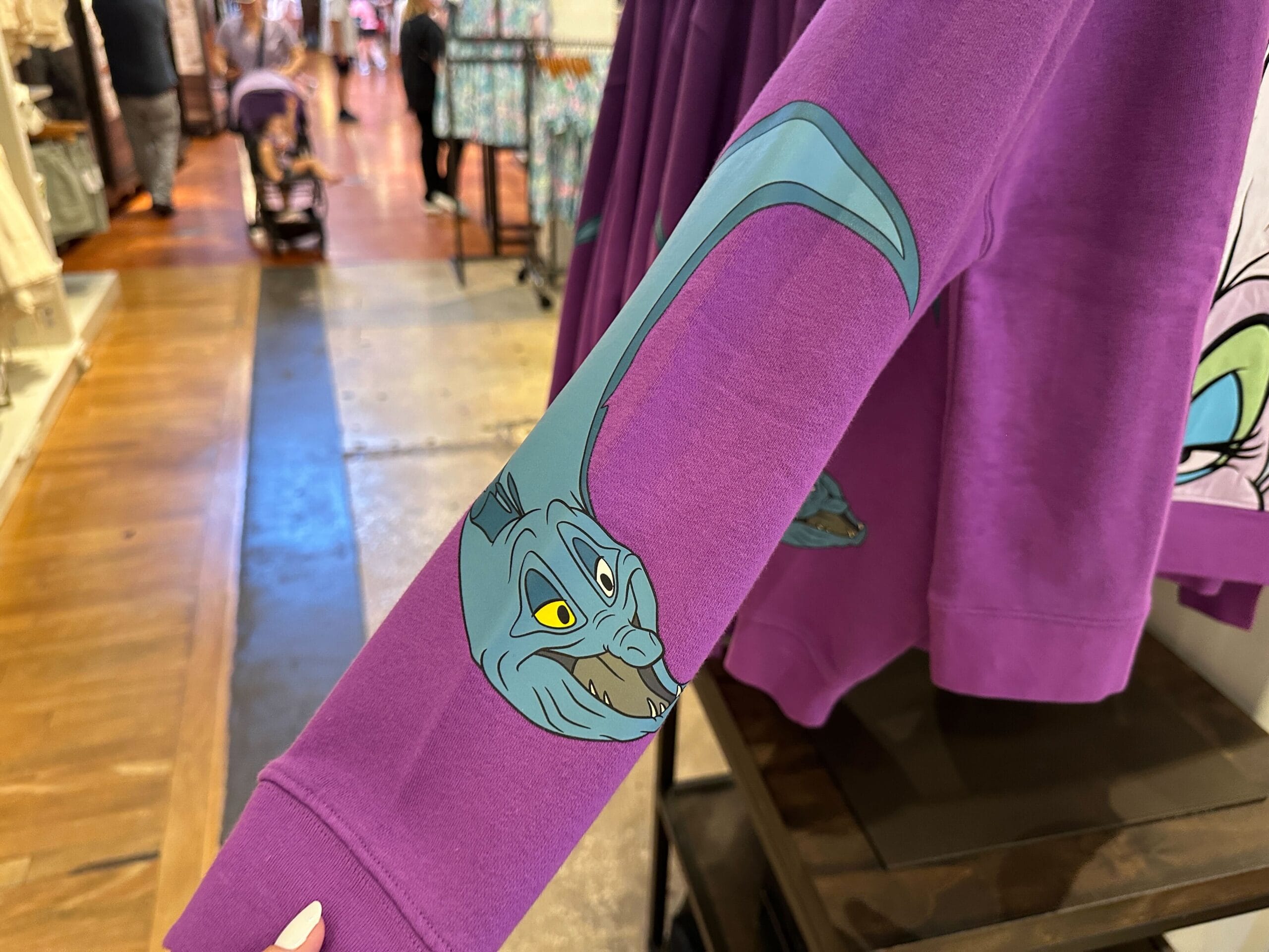 Manche de sweat violet affichant Génie d’Aladdin avec son bras long et bleu