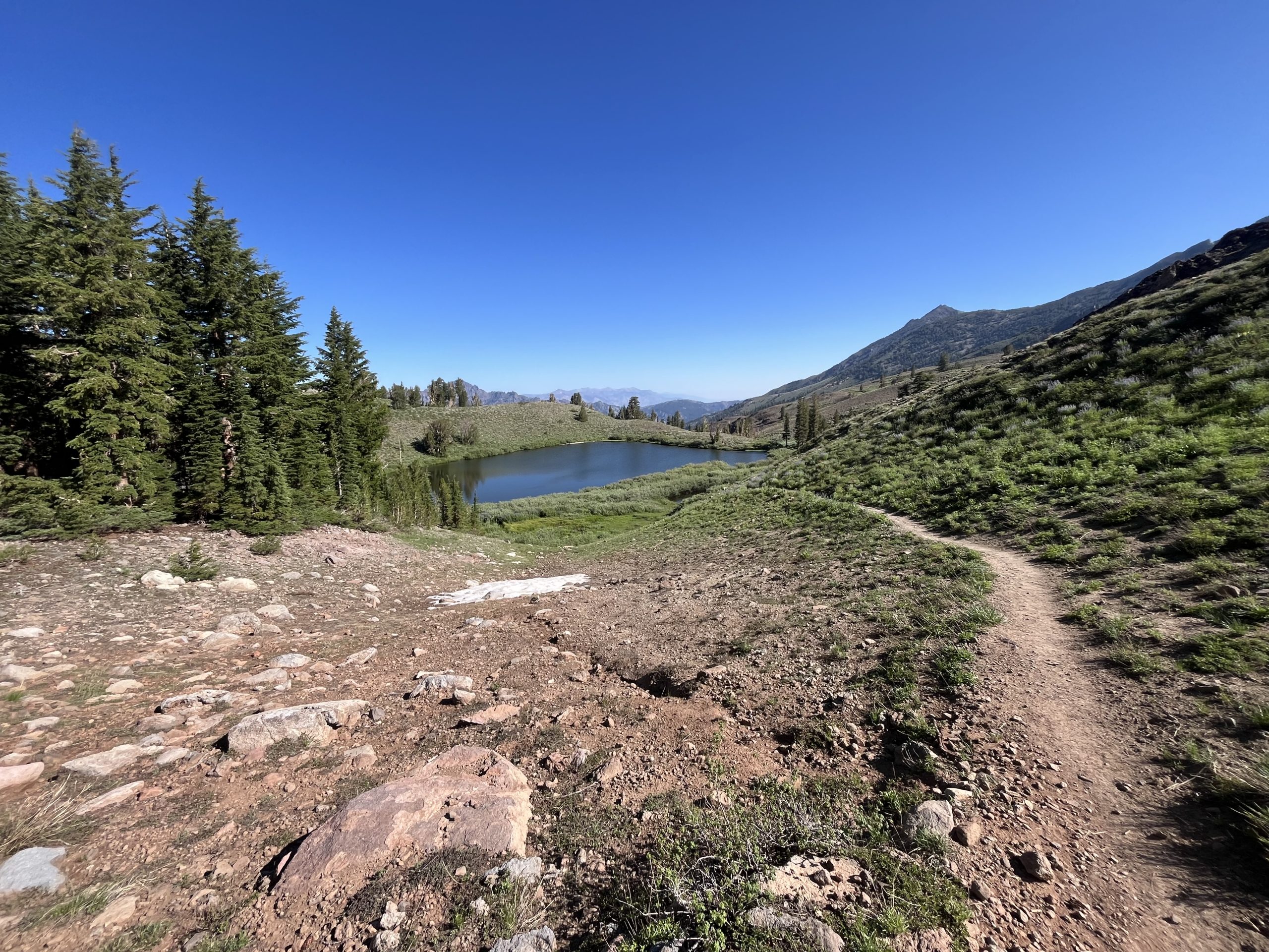 Le sentier longe un lac et une falaise