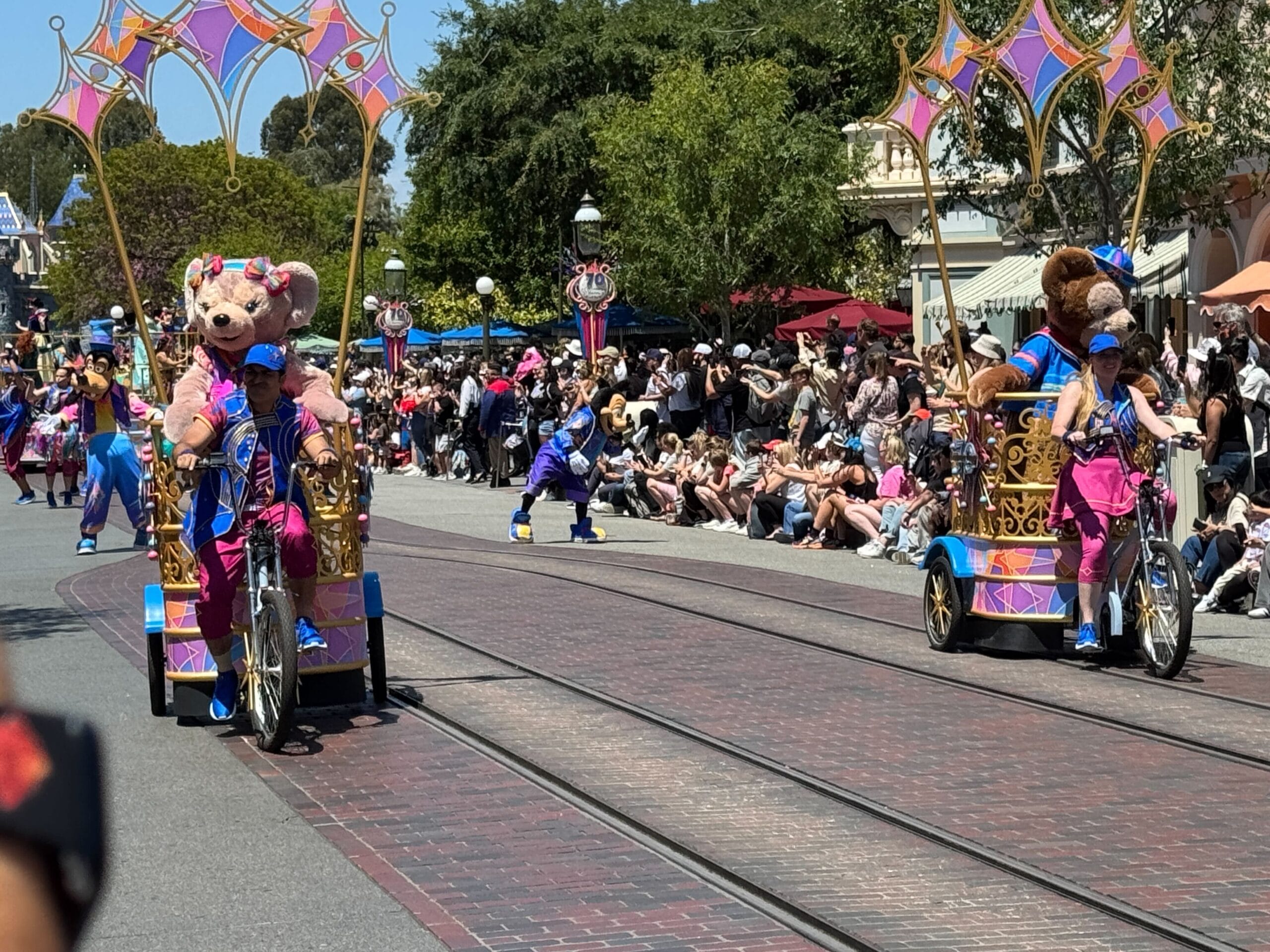 Celebrate Happy Cavalcade coloré avec des participants en costumes d'ours et vélos décorés, acclamés par la foule.